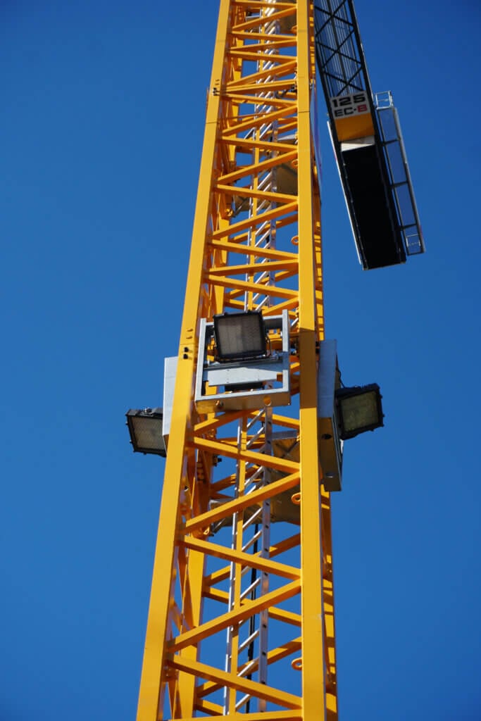LED-floodlights gemonteerd op een torenkraan tegen een blauwe lucht