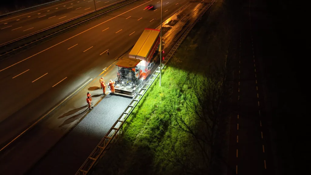 Verblindingsvrije LED-werklamp geeft veel licht rond een asfalteermachine 's nachts