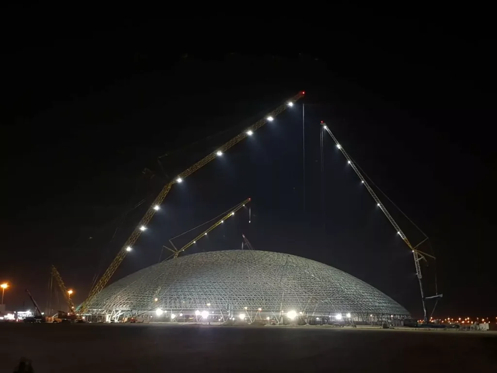 Jeddah Superdome bei Nacht mit drei Raupenkränen und LED-Flutlicht