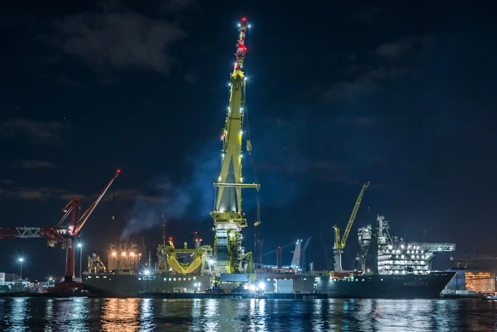 Buque grúa Bokalift 2 de noche en el muelle con la cubierta de trabajo completamente iluminada